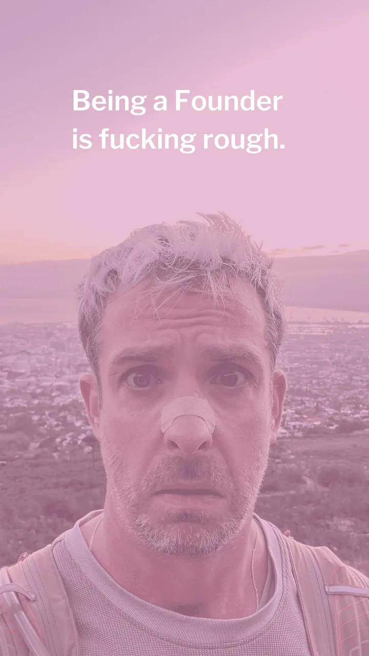 A man with a plaster on his nose looks into the camera above a city at dusk. Caption: Being a Founder is fucking rough.